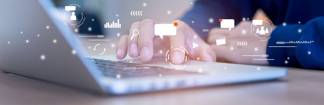 Close-up of hands typing on a laptop with various technology-related icons overlaid