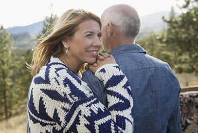 Middle aged couple hugging in the mountains
